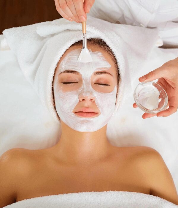 Woman receiving facial mask treatment at spa